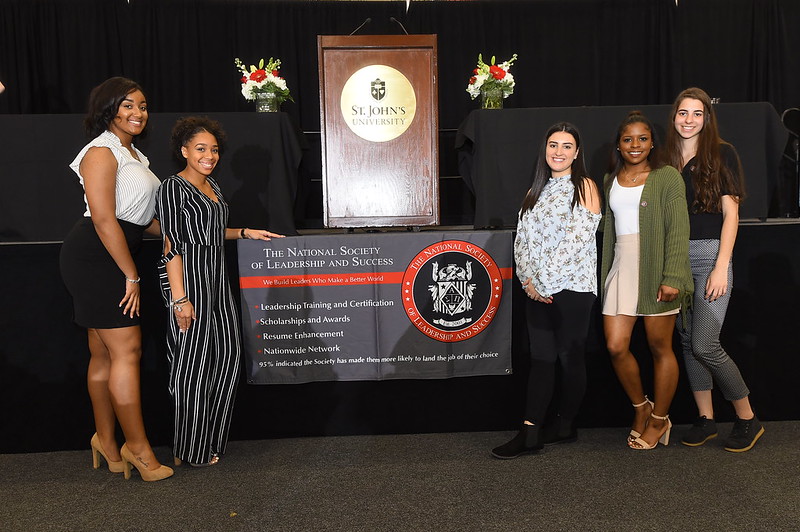 NSLS students posing for a photo in front of an NSLS banner