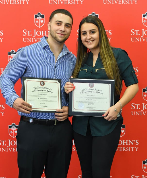 Two NSLS students posing with their diplomas