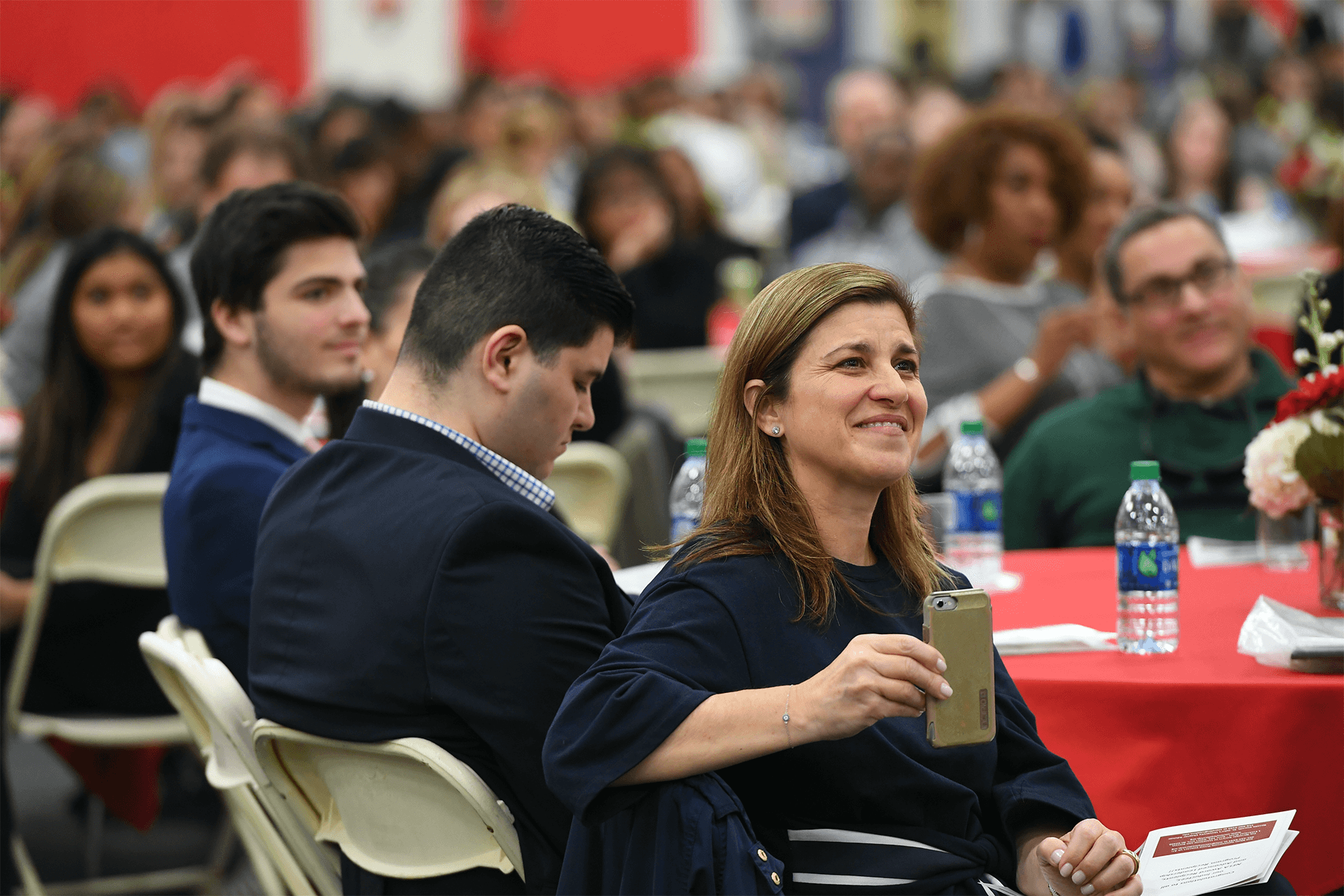 NSLS member smiling with a phone in her hand at an event